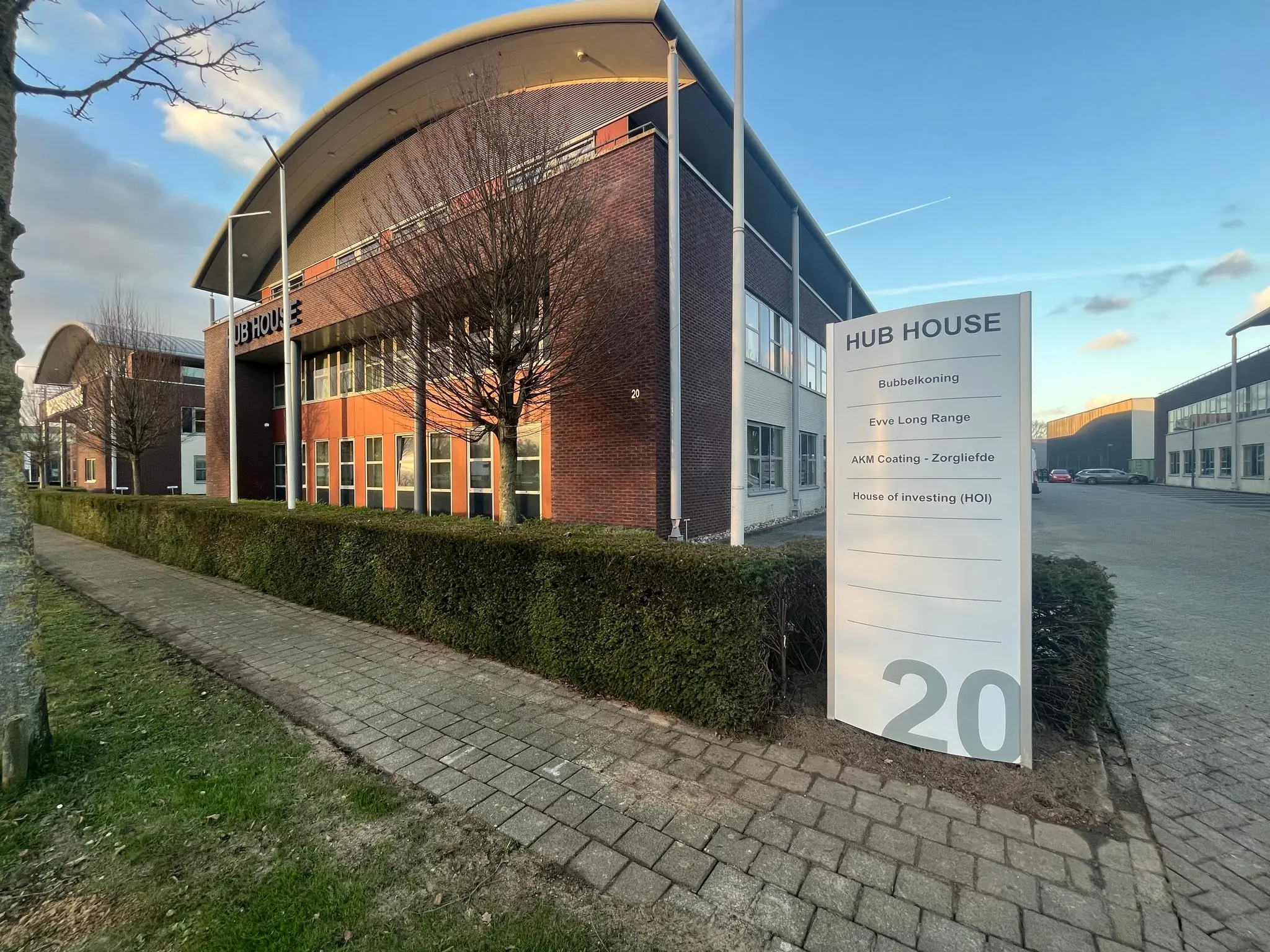 Kantoorgebouw HUB HOUSE met bedrijvennamen op een informatiebord en huisnummer 20.